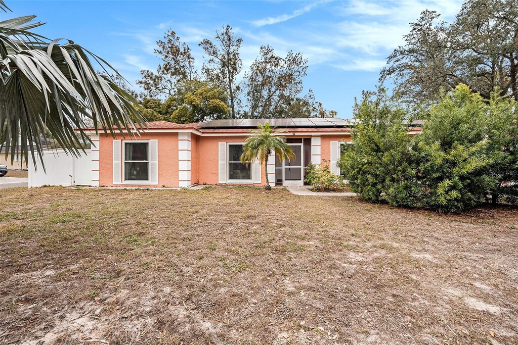 view of front of home featuring a front lawn and solar panels