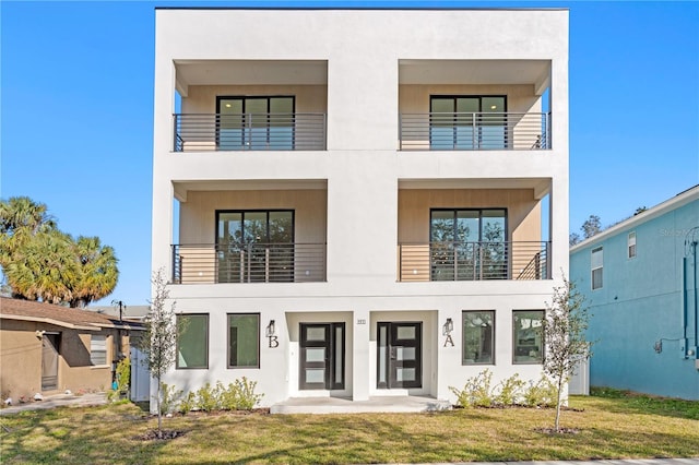 contemporary house featuring a patio area, a balcony, and a front lawn