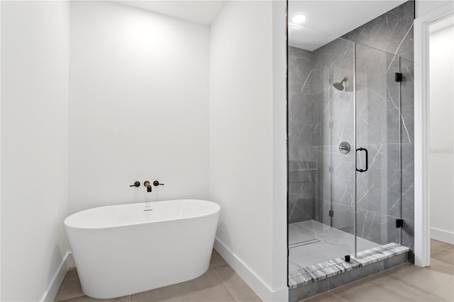 bathroom with tile patterned flooring and separate shower and tub