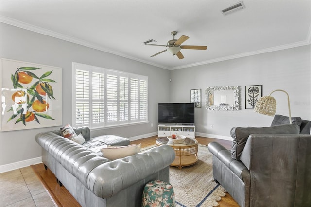 living room with ceiling fan, light tile patterned flooring, and ornamental molding