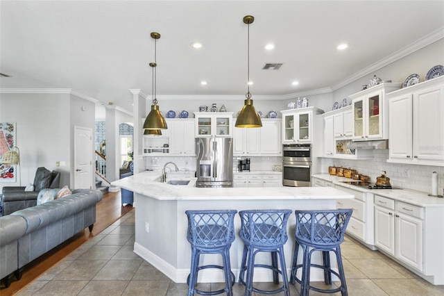 kitchen with hanging light fixtures, light tile patterned floors, stainless steel appliances, and white cabinetry