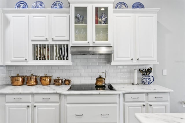 kitchen featuring white cabinetry, black electric cooktop, exhaust hood, and tasteful backsplash