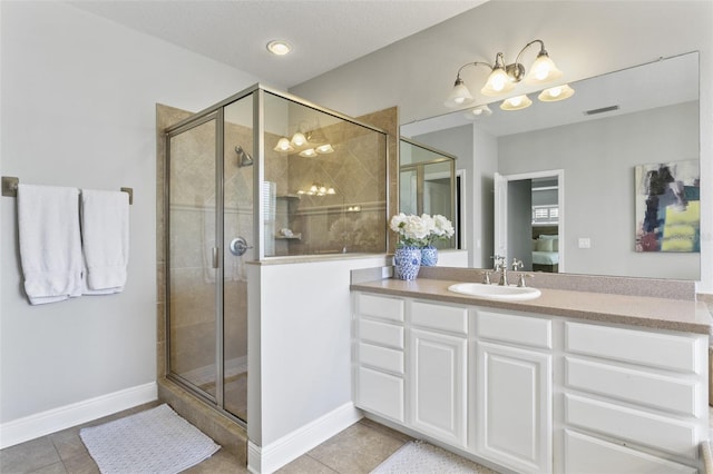 bathroom featuring an enclosed shower, vanity, and tile patterned flooring