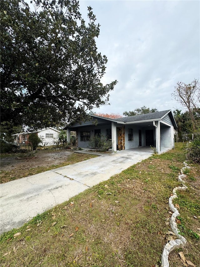 view of front of property with a front lawn and a carport