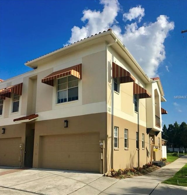 view of home's exterior with a garage, driveway, and stucco siding