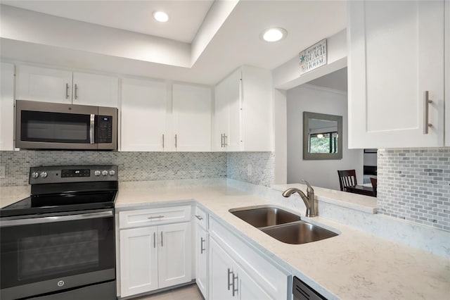 kitchen featuring decorative backsplash, sink, white cabinetry, stainless steel appliances, and light stone counters