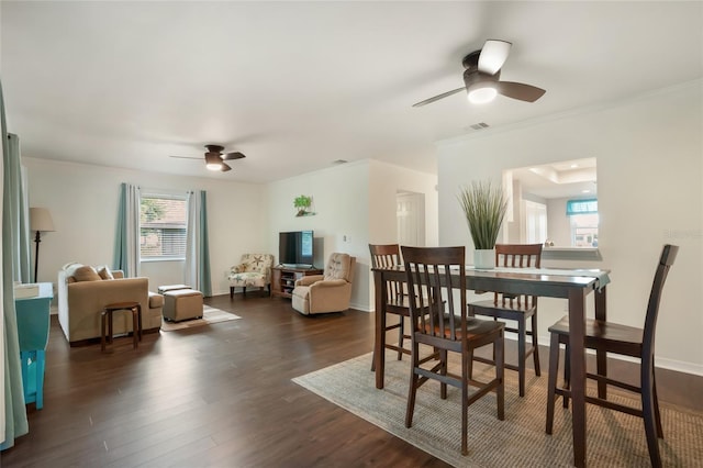 dining room with ceiling fan, dark wood-type flooring, and crown molding