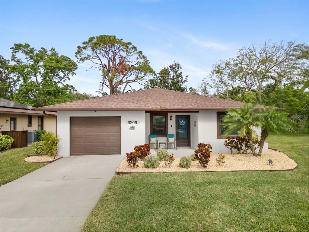 ranch-style home with central air condition unit, a front lawn, and a garage