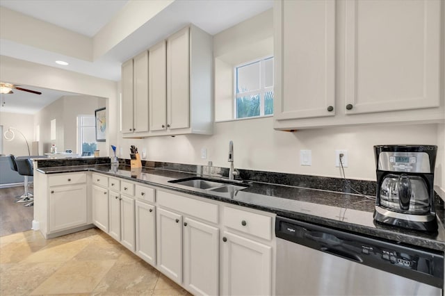 kitchen featuring sink, white cabinetry, dishwasher, ceiling fan, and dark stone countertops