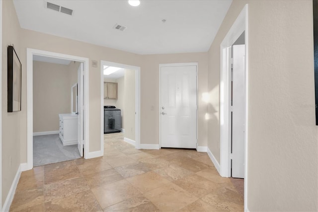 12077 Gandy Blvd N Unit 344, Saint Petersburg, FL 33702 - hall with washer / clothes dryer, stone tile floors, and baseboards