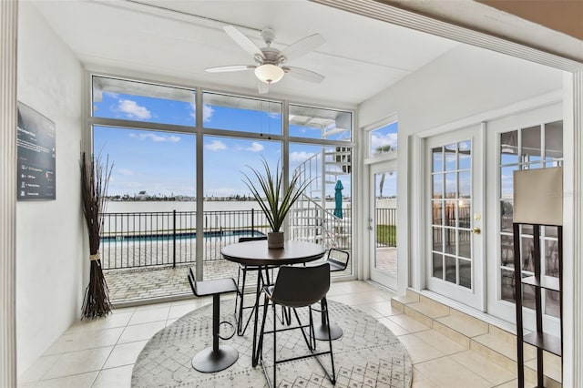 sunroom with a water view, ceiling fan, and french doors