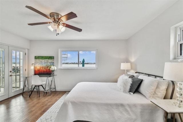 bedroom featuring multiple windows, dark hardwood / wood-style floors, access to outside, and french doors