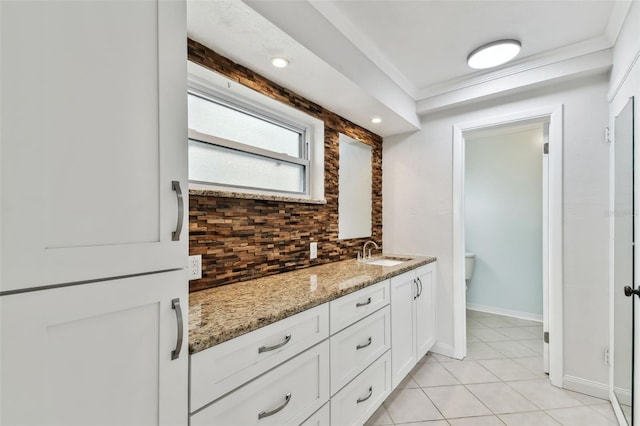 bathroom featuring decorative backsplash, ornamental molding, vanity, toilet, and tile patterned floors