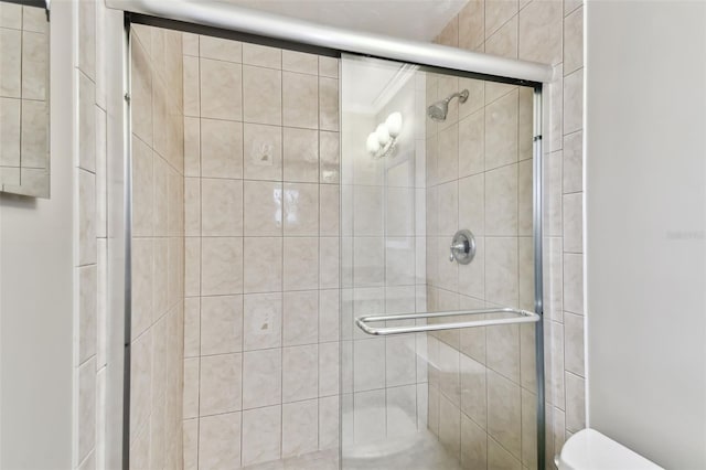 bathroom featuring toilet and a shower with shower door