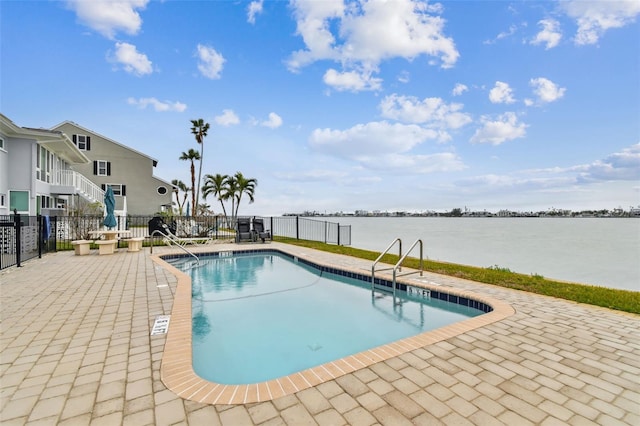 view of swimming pool with a water view and a patio