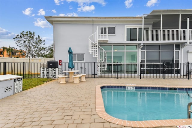 back of property with a community pool and a patio area