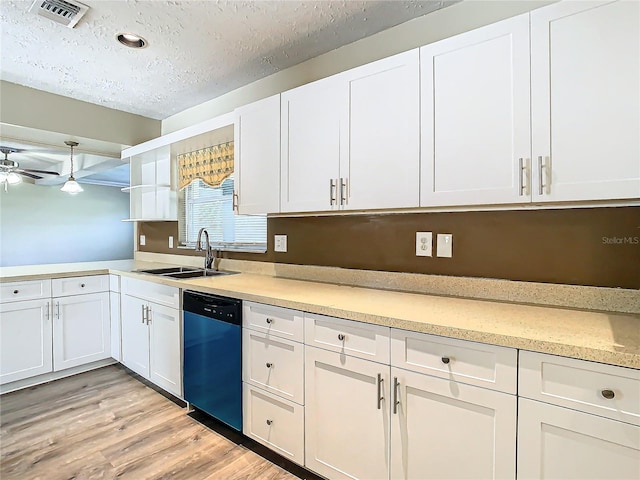 kitchen featuring black dishwasher, sink, white cabinets, and a textured ceiling