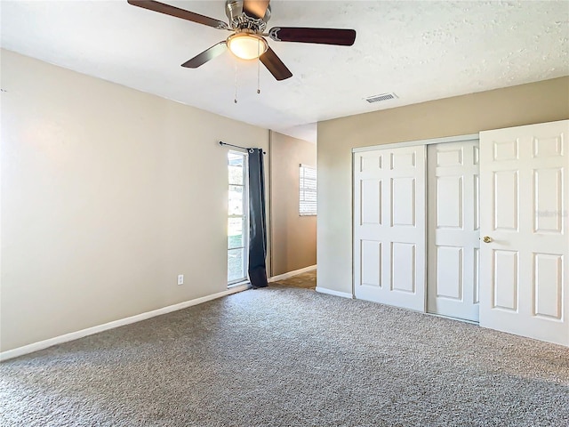 unfurnished bedroom with carpet floors, a textured ceiling, ceiling fan, and a closet