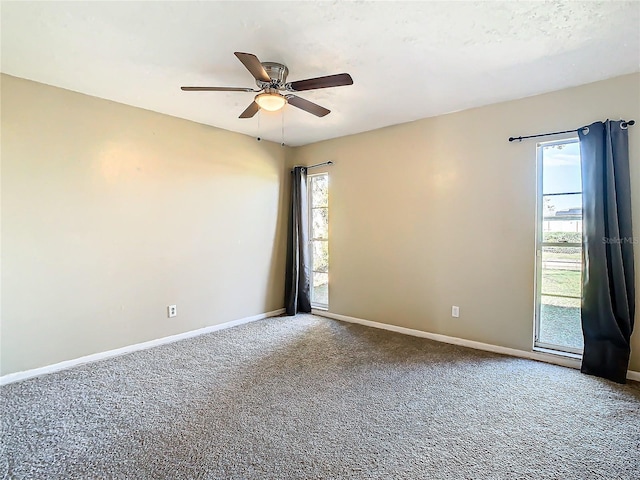 carpeted spare room featuring ceiling fan