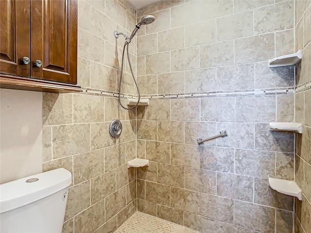 bathroom featuring a tile shower and toilet