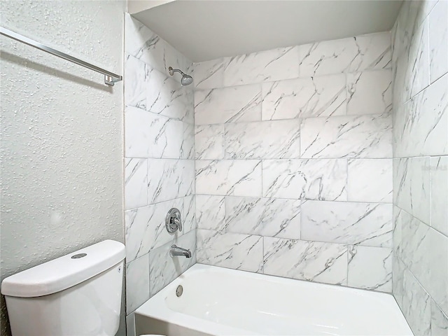 bathroom with tiled shower / bath combo and toilet