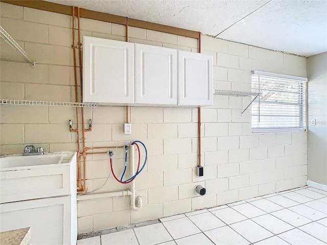 laundry room featuring cabinets, hookup for a washing machine, and light tile patterned floors