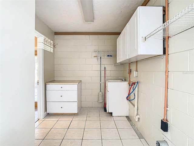 laundry area featuring washer hookup, cabinets, and light tile patterned flooring