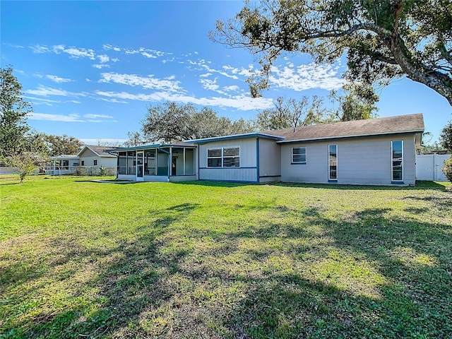 back of house featuring a yard and a sunroom