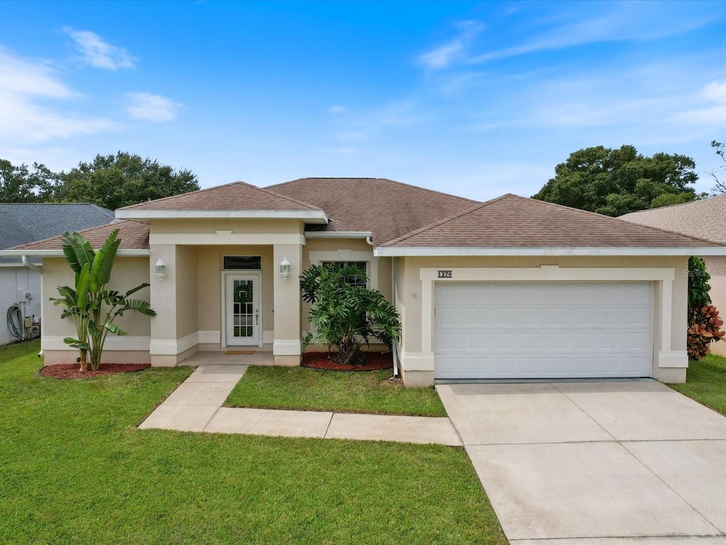 view of front of house featuring a front lawn and a garage