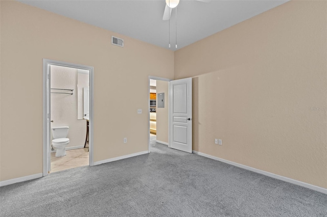 unfurnished bedroom featuring light carpet, connected bathroom, and ceiling fan