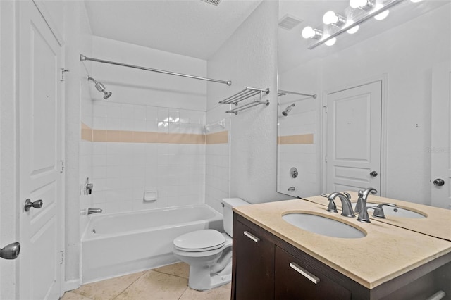 full bathroom featuring vanity, toilet, tiled shower / bath combo, and tile patterned flooring