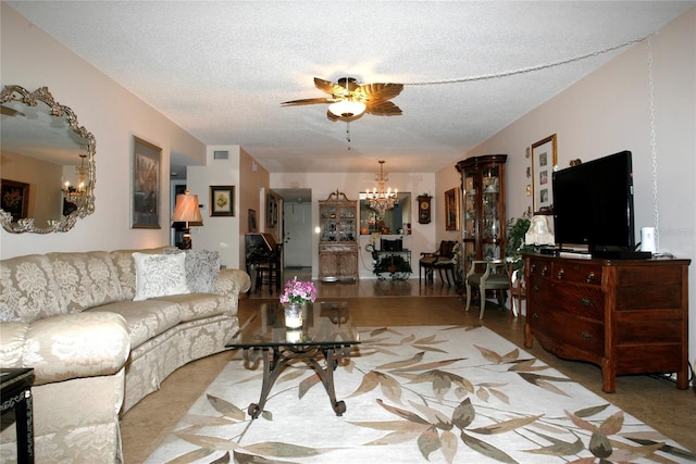 living room featuring ceiling fan with notable chandelier and a textured ceiling