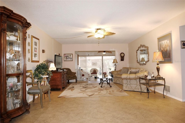 living room featuring ceiling fan and a textured ceiling