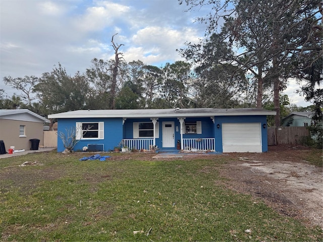 single story home with a garage, a front yard, and covered porch