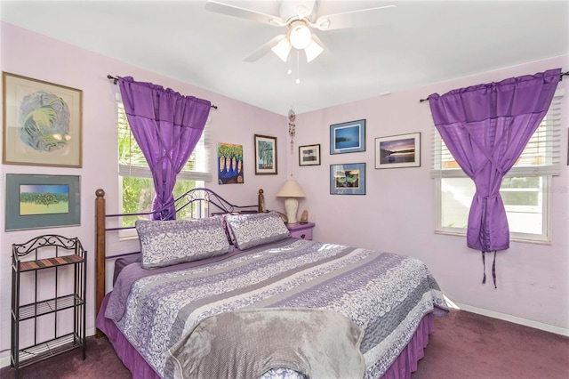 bedroom featuring ceiling fan, dark carpet, and multiple windows