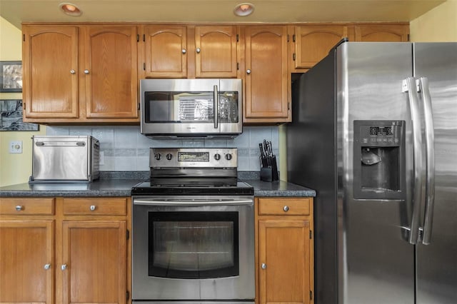 kitchen with stainless steel appliances, dark countertops, and decorative backsplash