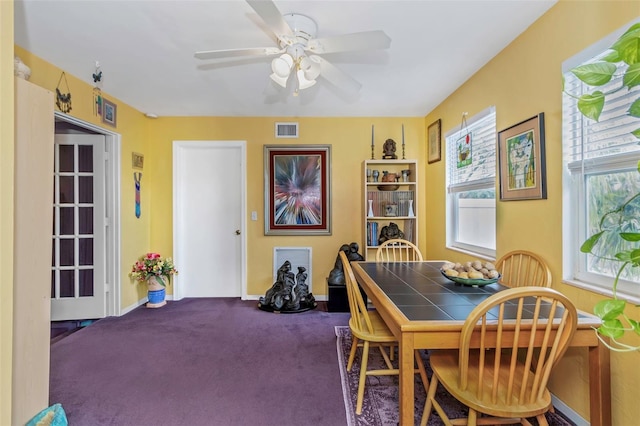 dining space with carpet and ceiling fan