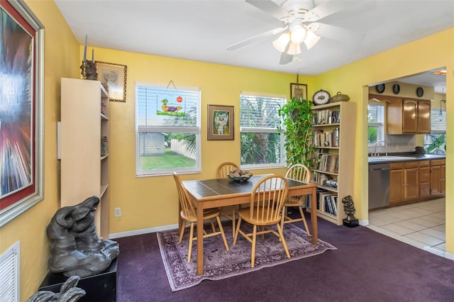 dining area with light carpet, ceiling fan, and sink