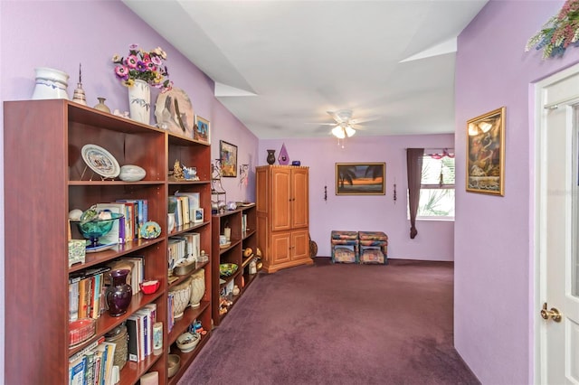 interior space featuring ceiling fan and dark colored carpet