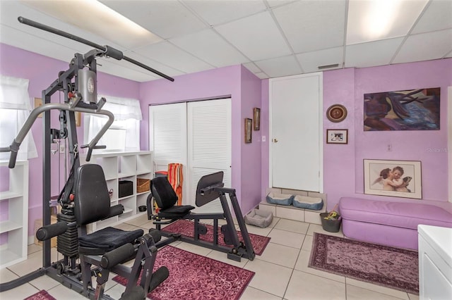 exercise room featuring tile patterned floors, visible vents, and a drop ceiling