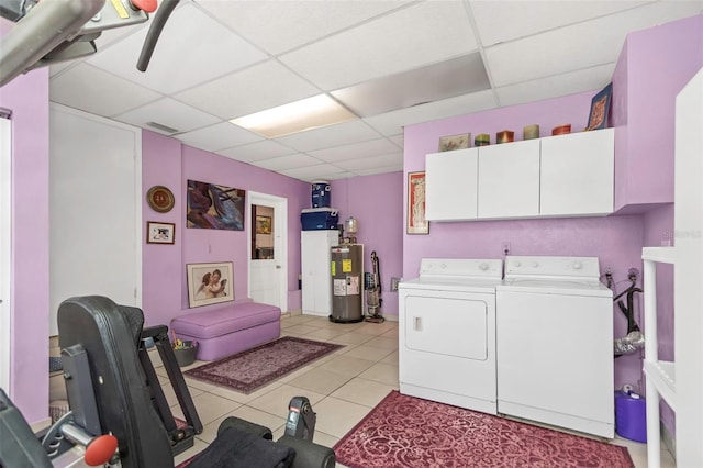 washroom with light tile patterned floors, water heater, independent washer and dryer, and cabinets