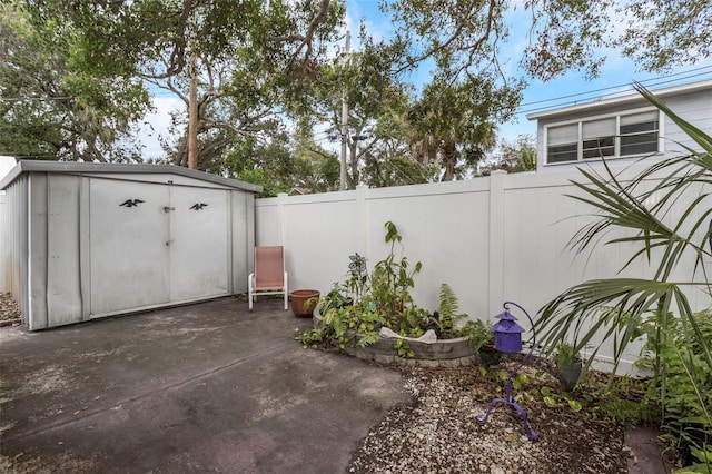 view of patio / terrace with a fenced backyard, an outbuilding, and a storage shed