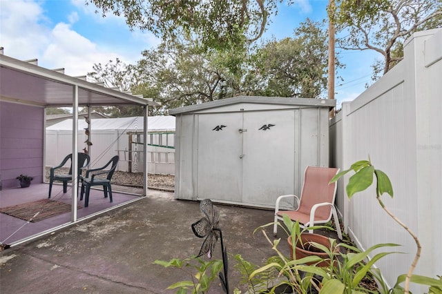 view of patio / terrace with a storage unit, an outbuilding, and a fenced backyard