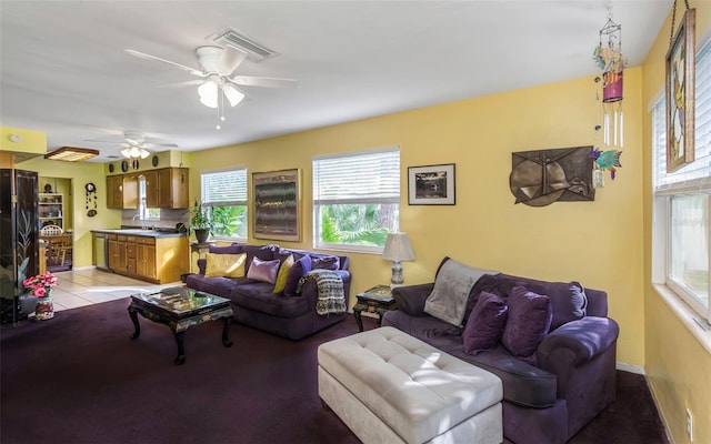 living room with light tile patterned flooring, visible vents, and a ceiling fan