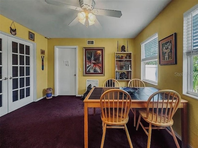 carpeted dining room featuring baseboards, french doors, visible vents, and ceiling fan