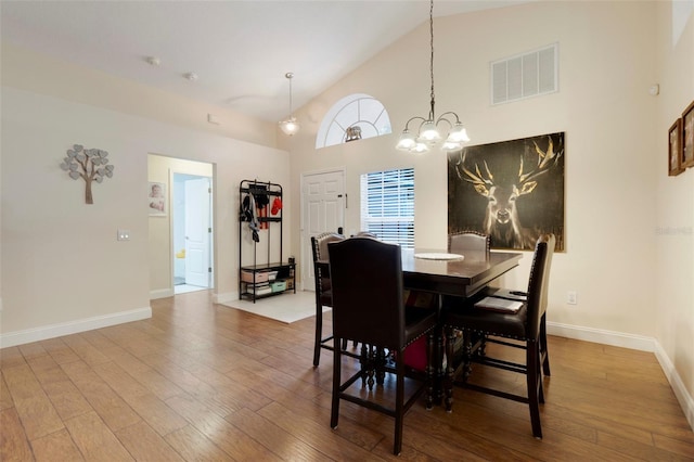 4605 Lisette Cir, Brooksville, FL 34604 - dining room with high vaulted ceiling, wood-type flooring, baseboards, and a chandelier