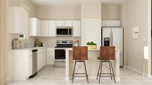 kitchen with white cabinets, appliances with stainless steel finishes, light tile patterned flooring, and a kitchen breakfast bar