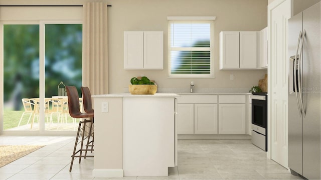 kitchen featuring white cabinets, stainless steel fridge, a kitchen island, and a kitchen breakfast bar