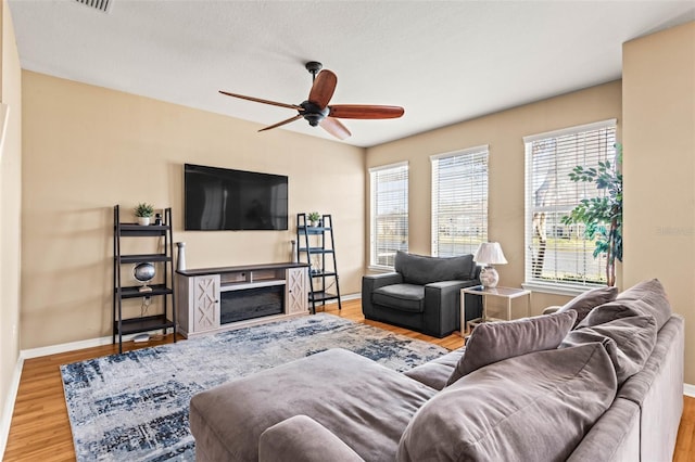 living room with ceiling fan and light hardwood / wood-style flooring