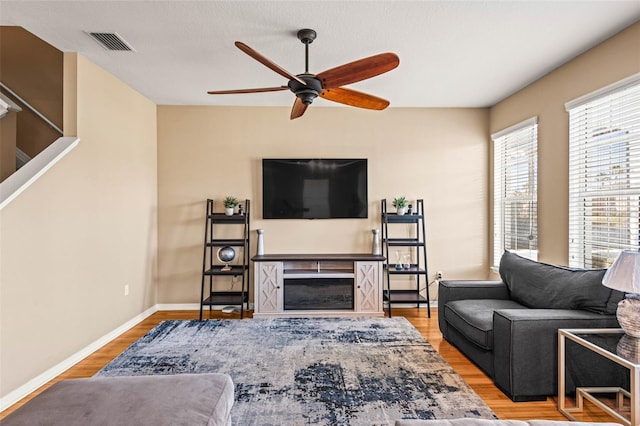 living room featuring ceiling fan and light hardwood / wood-style flooring